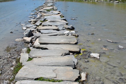 Brücke aus Steinen über ein Wasser symbolisiert palliative Begleitung daheim