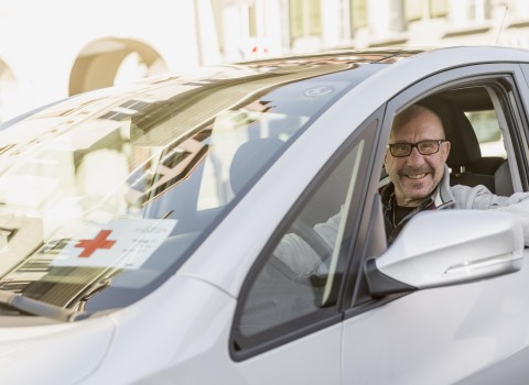 Ein freiwilliger Fahrer ist als Rotkreuz-Fahrdienst unterwegs und spendet seine Zeit an mobilitätsbedürftige Menschen.